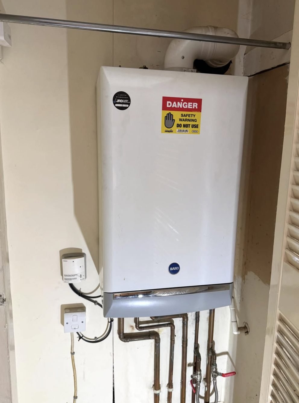 Gas boiler with a Danger Do Not Use safety warning notice attached after an inspection