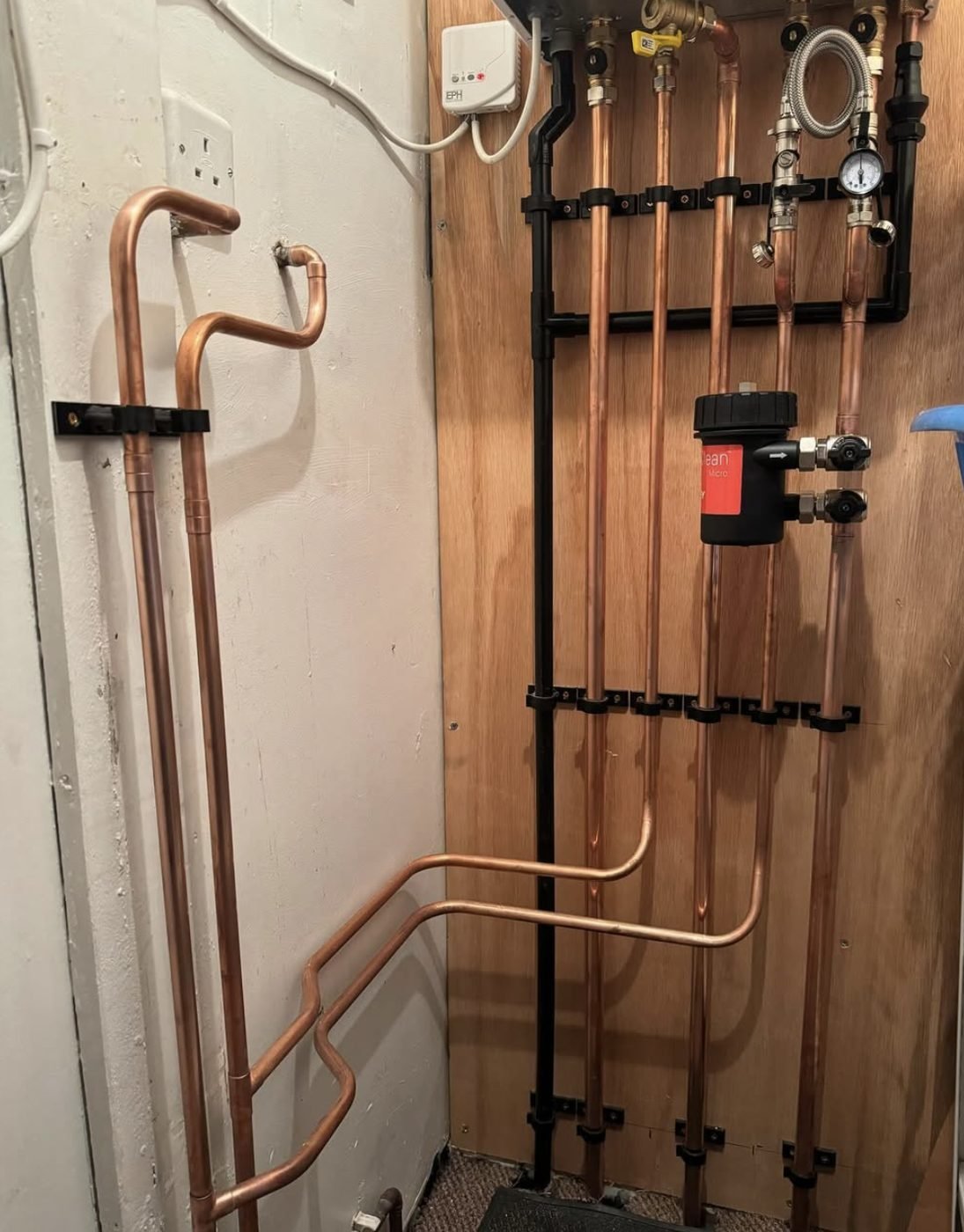 Copper heating pipework on a board with a magnetic filter, valves and pressure gauge