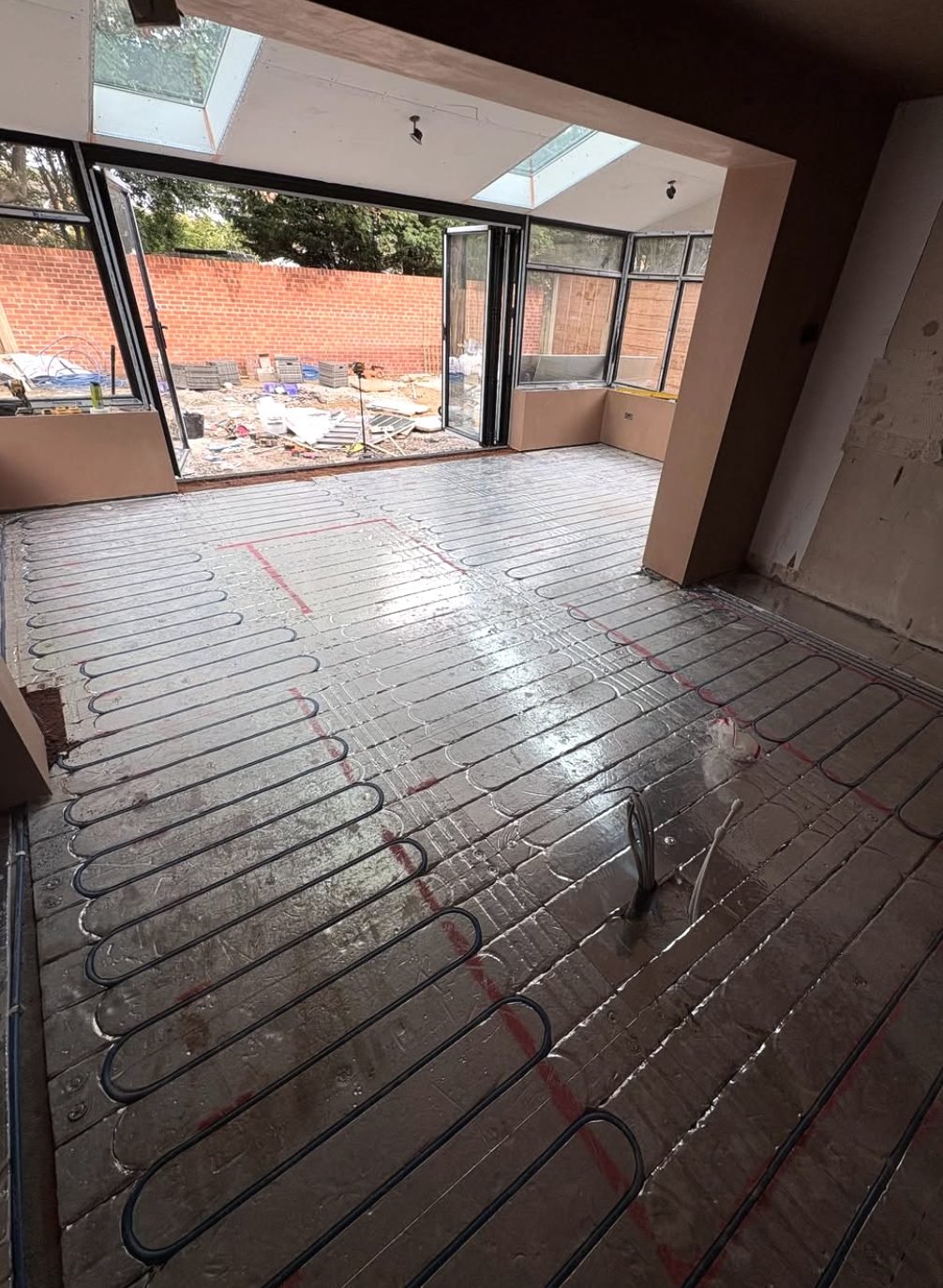 Wet underfloor heating pipework laid across a floor before screeding